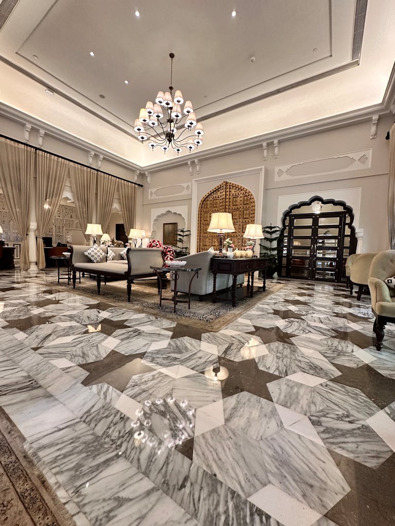 Opulent hotel lobby featuring marble floors, chandeliers, and plush seating in Jaipur.